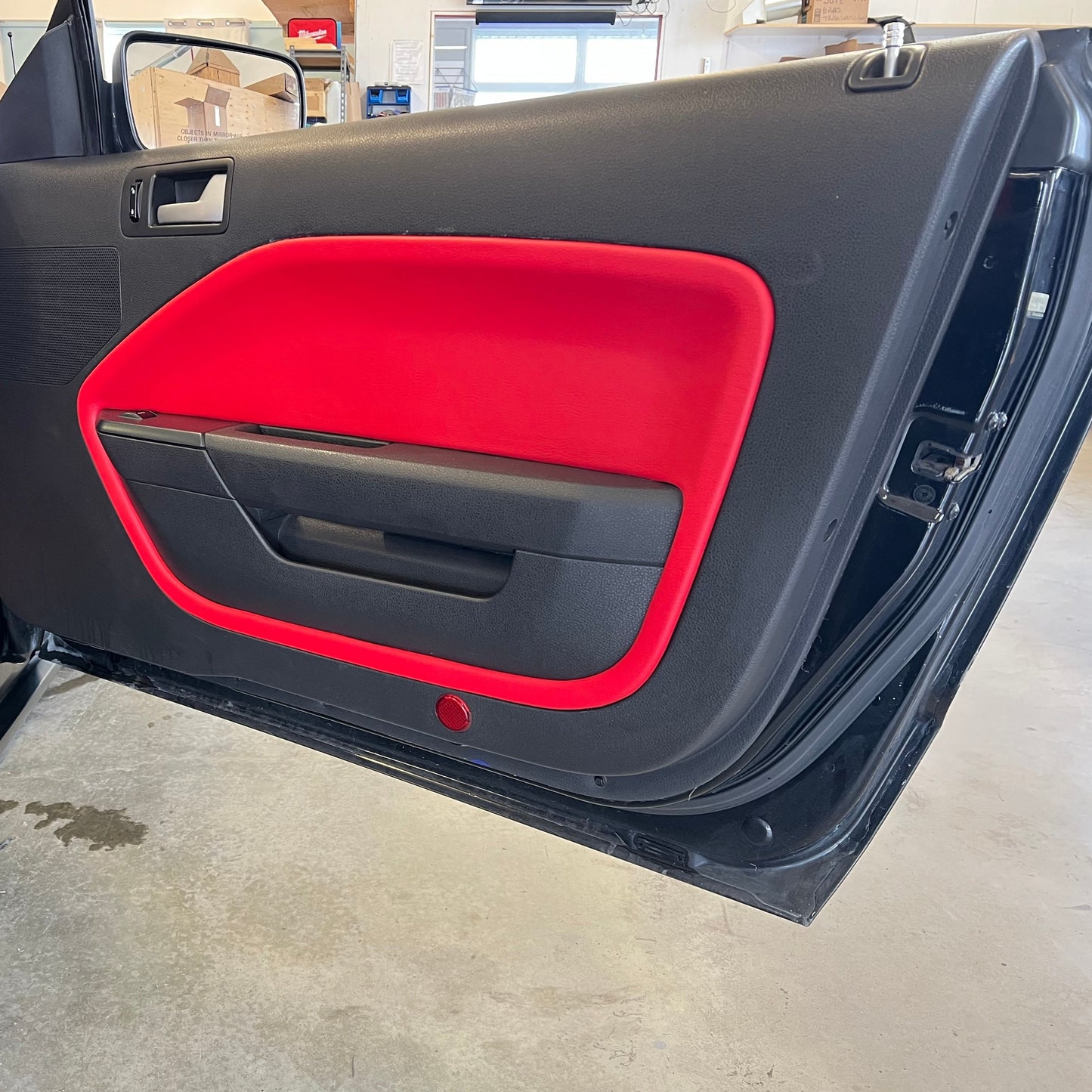 Panneau de plastique recouvert de vinyle rouge collé sur la porte d'origine